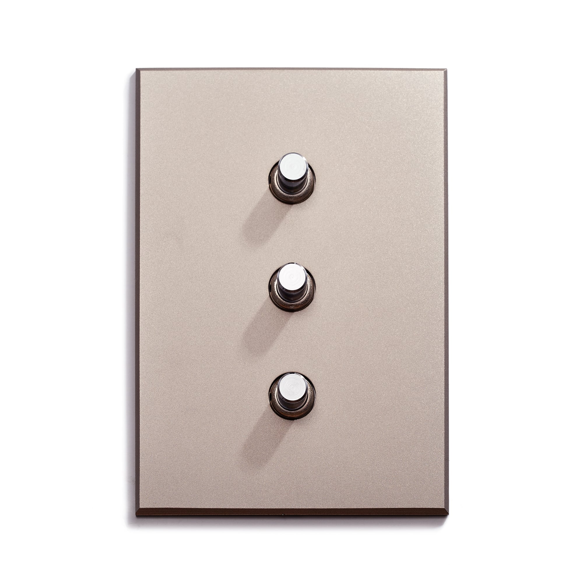 A modern light switch plate with three circular buttons on a solid color wall.