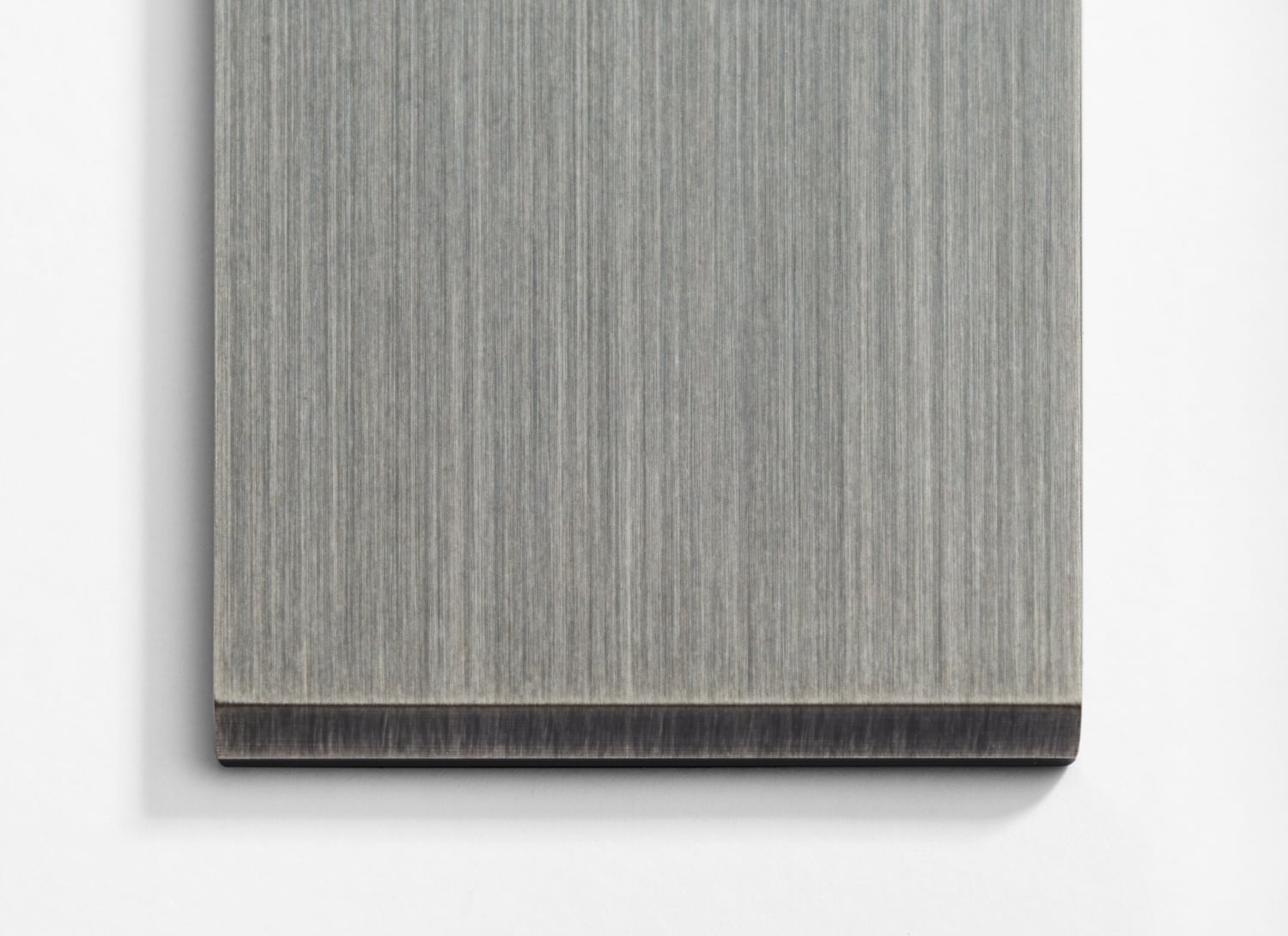 A piece of gray wood on a white wall.