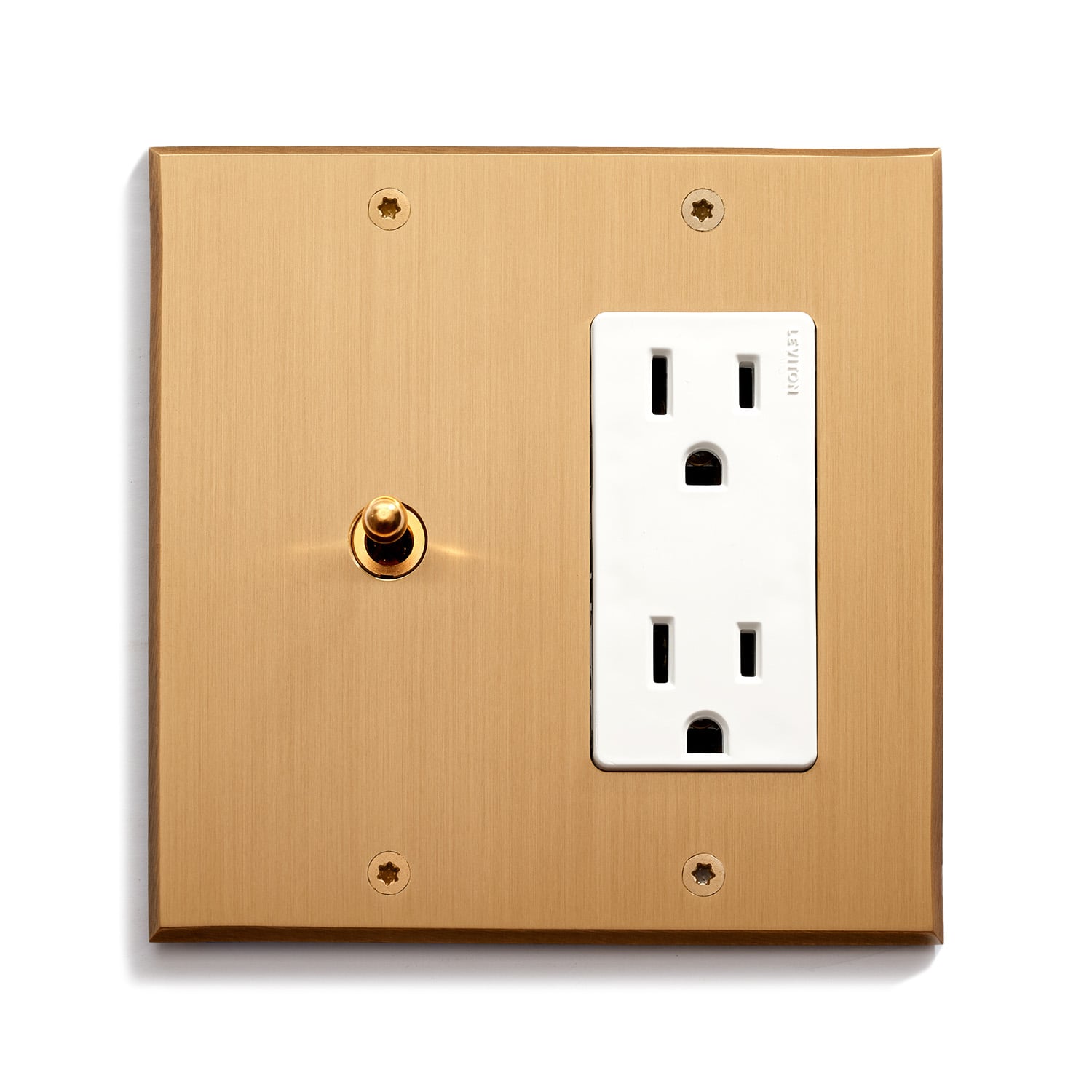 A gold-colored square electrical plate with a toggle switch and a dual outlet, mounted on a white background.