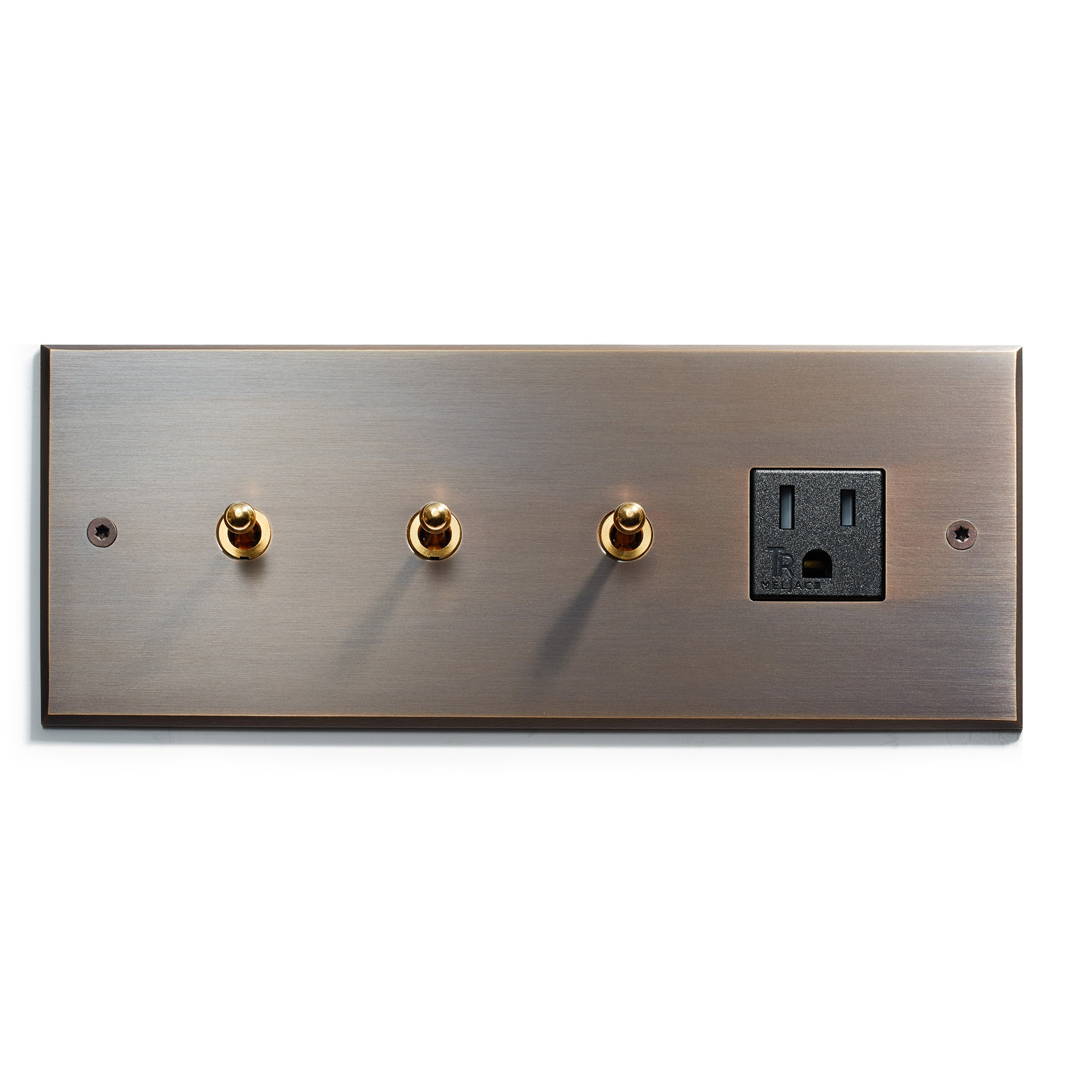 A sleek, modern wall plate featuring three brass toggle switches and one black electrical outlet, mounted on an elegant brushed metal backdrop.