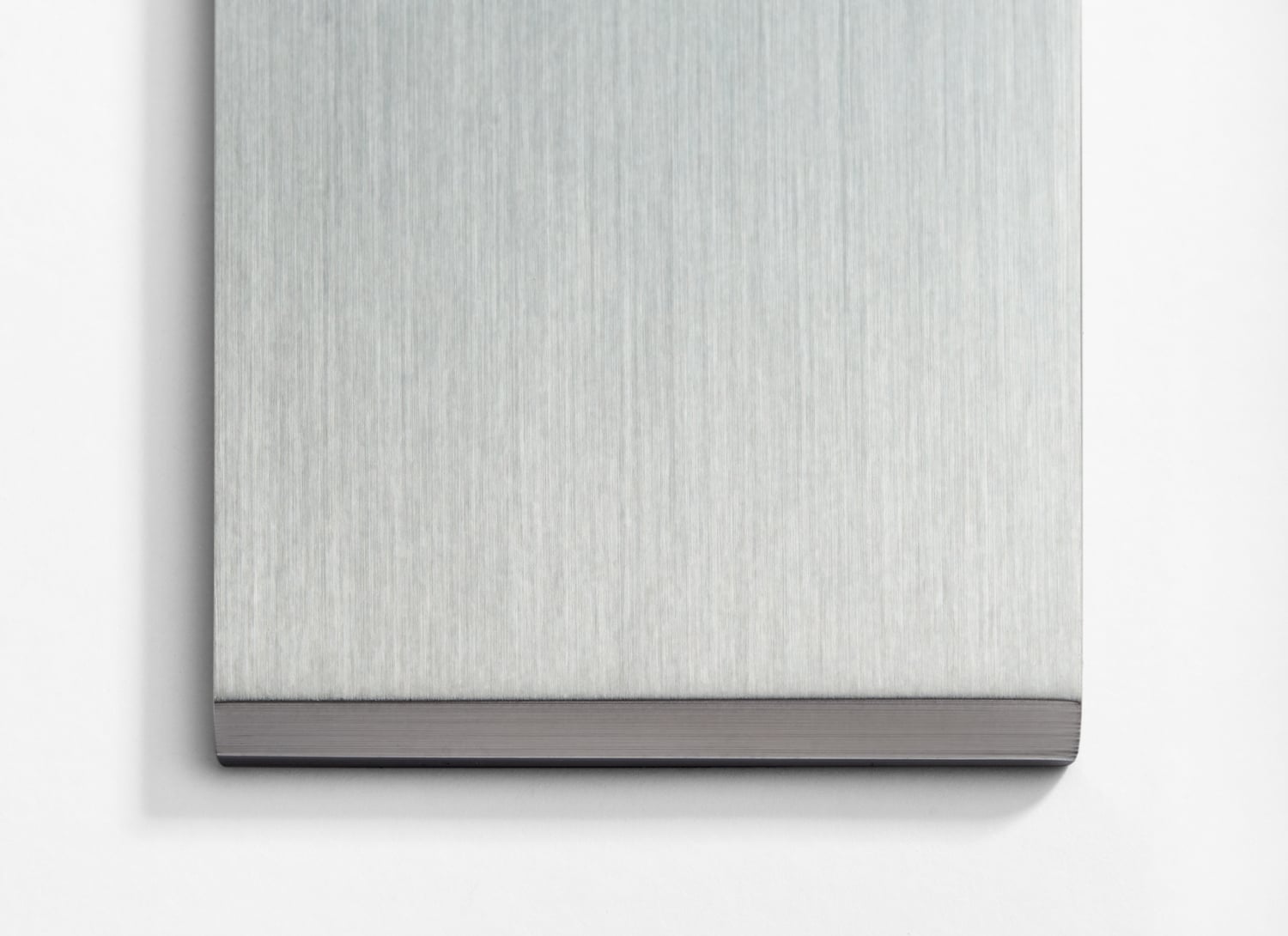 A stainless steel plate on a white wall.