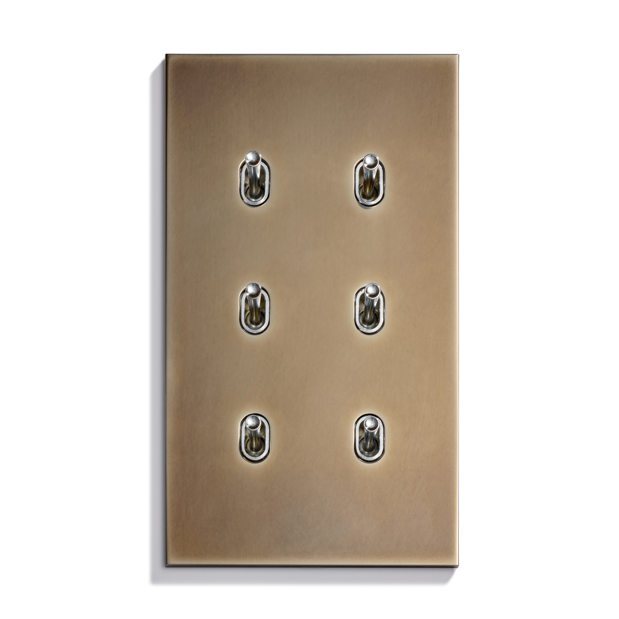 A brass switch plate with six small, round, metallic toggle switches arranged in two columns of three, mounted on a plain background.