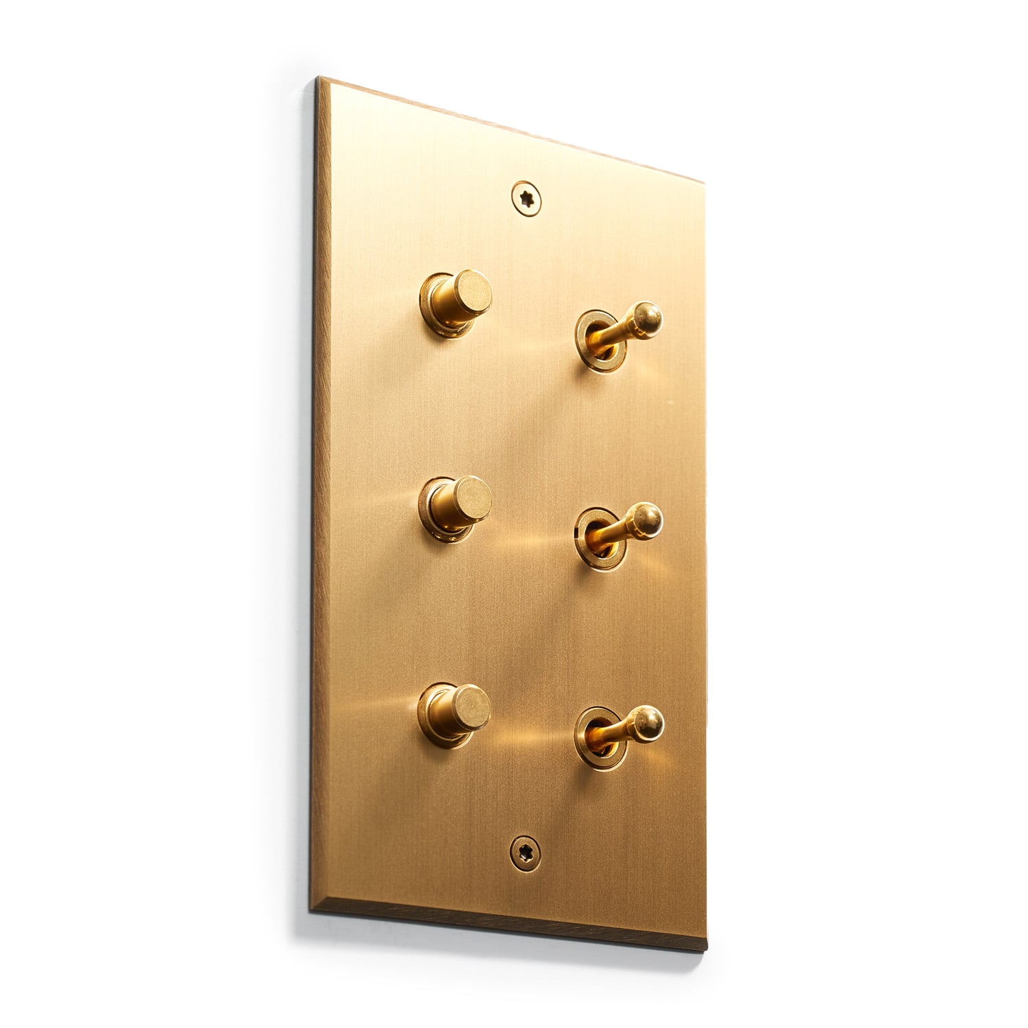A polished brass light switch plate with six toggle switches arranged in two vertical columns of three. The switches have a vintage-style design and the plate has a brushed metallic finish.