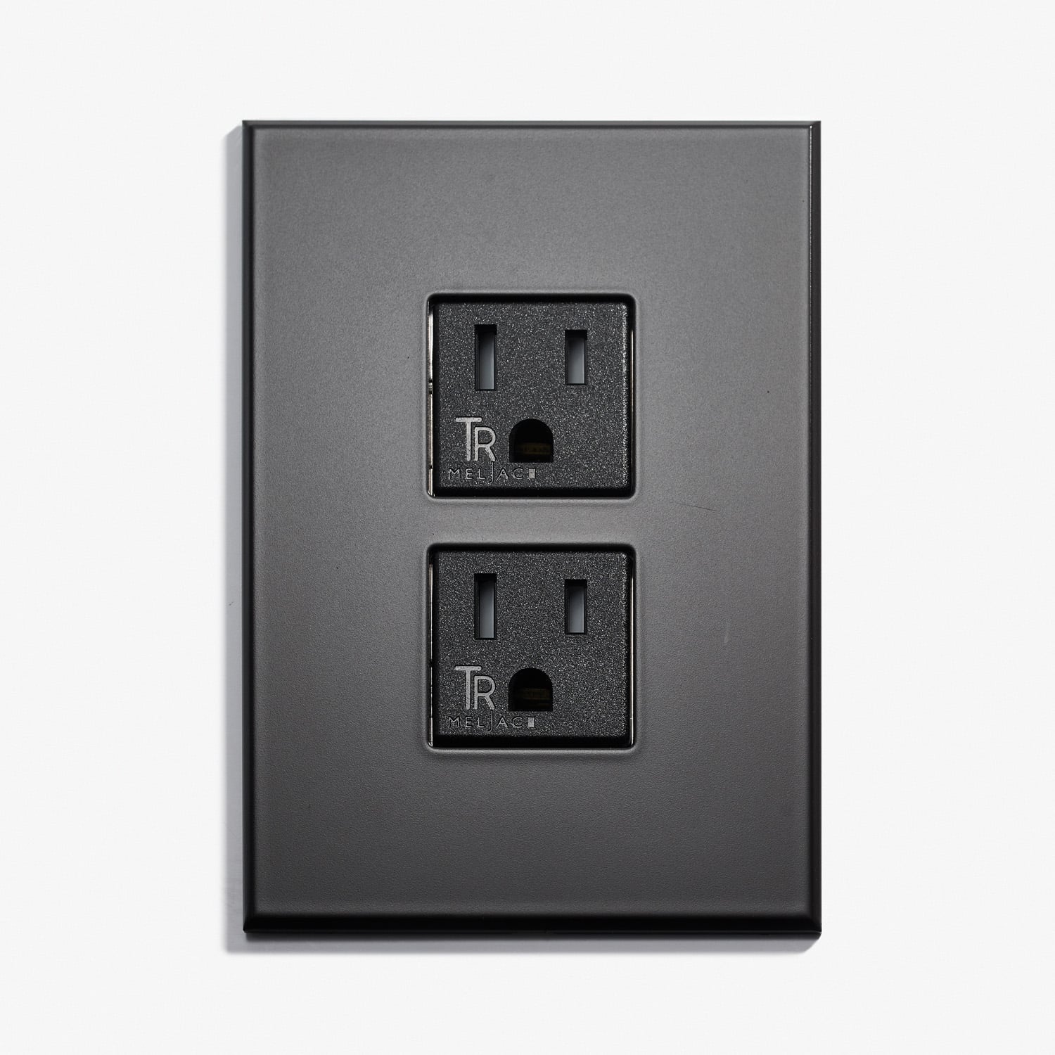 A black wall plate with two outlets on it.