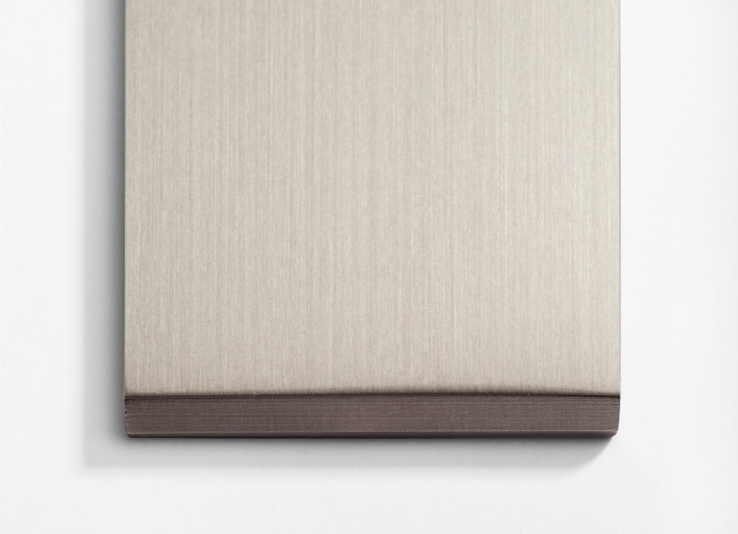 A beige and brown piece of paper hanging on a wall.