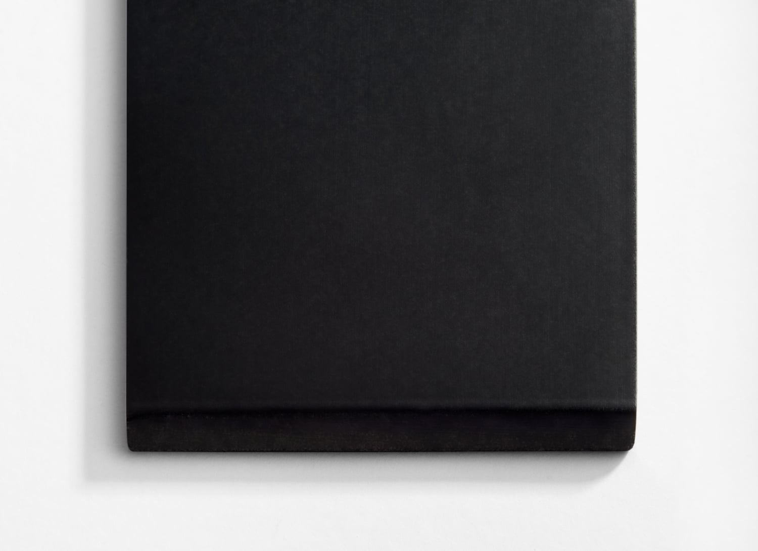 A black notebook on a white surface.