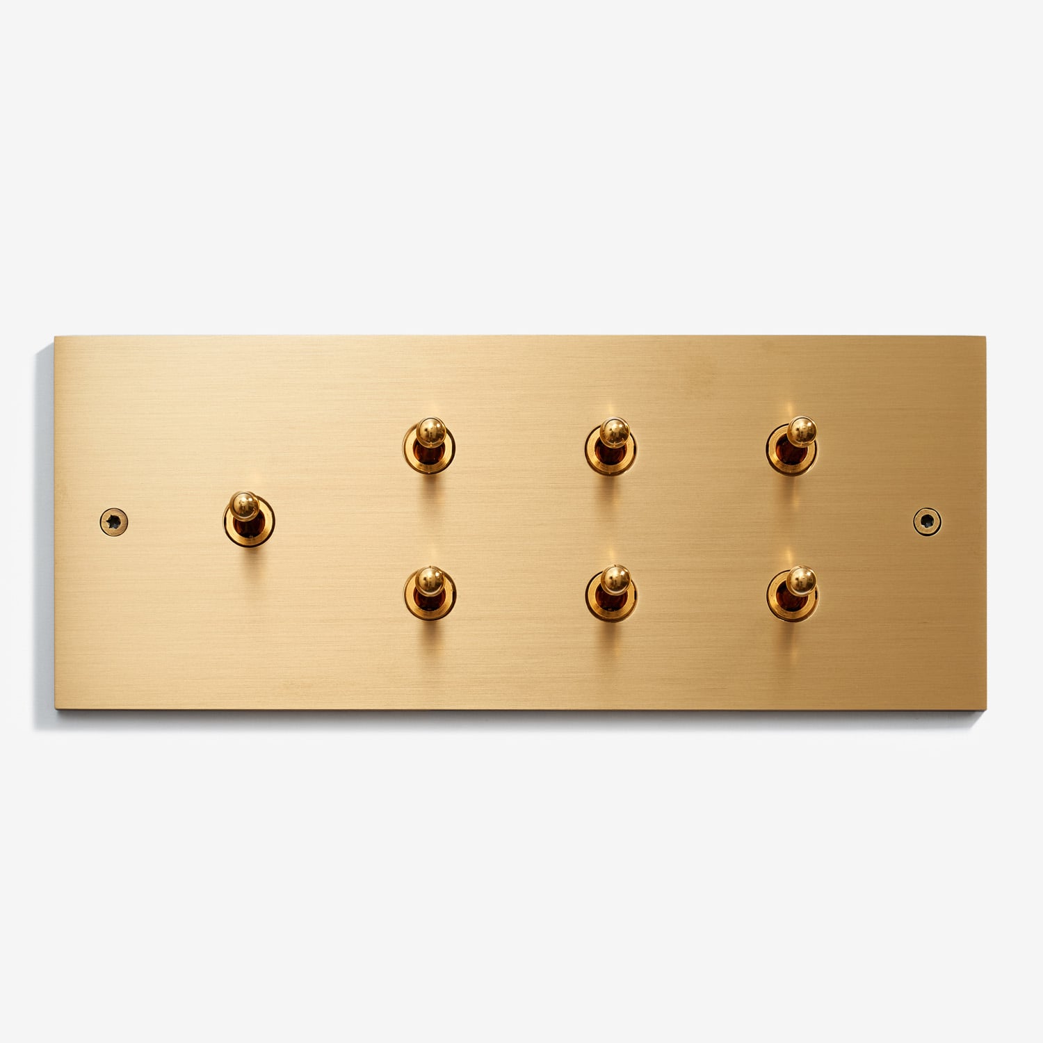 Elegant brass switch plate with multiple round buttons, offering minimalist luxury for interior design.