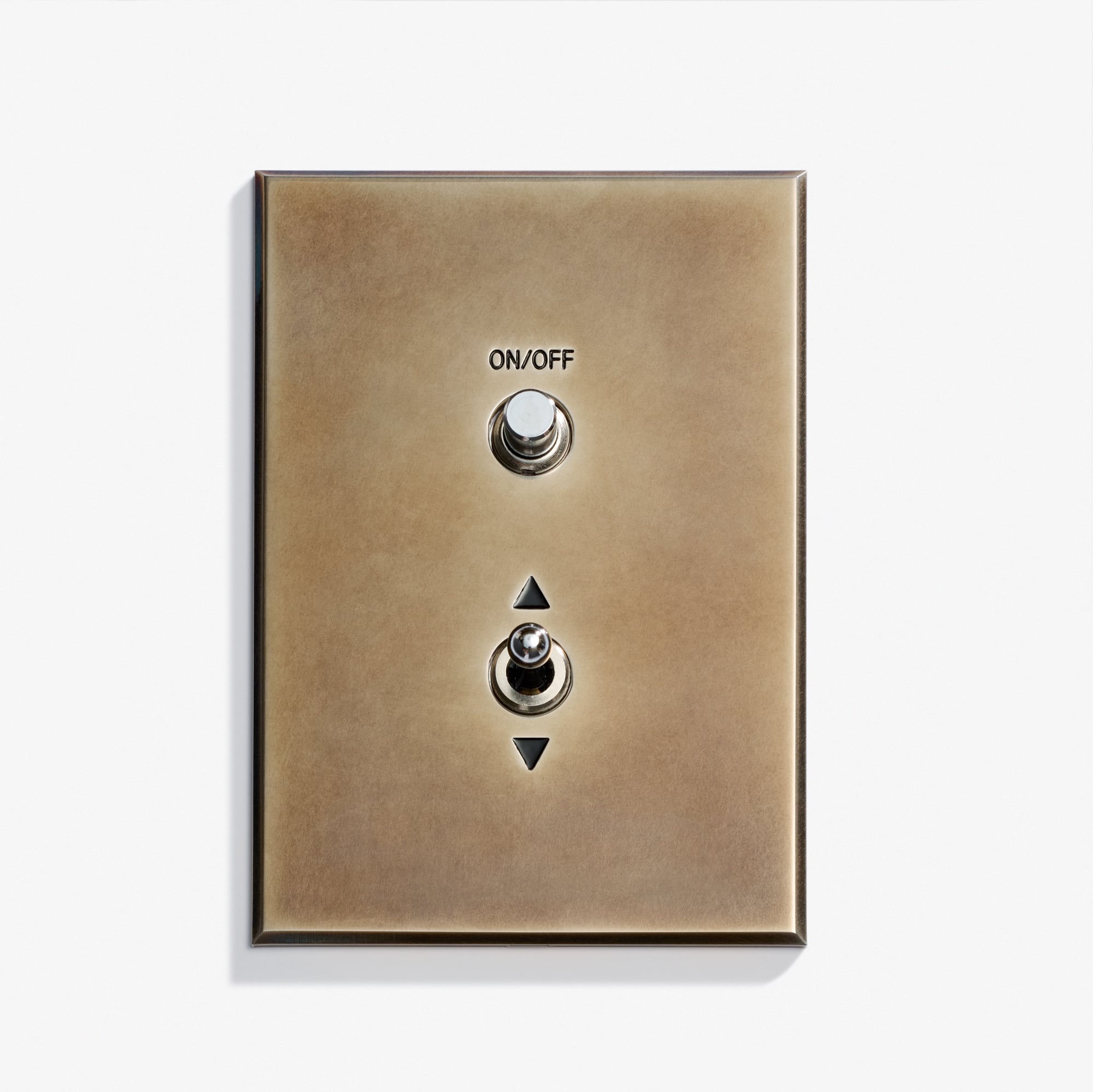 A metallic Classique Keypad 38 x 117 wall switch plate with two toggle switches, labeled "ON/OFF" at the top and arrows pointing up and down for the bottom switch, set against a plain white background.