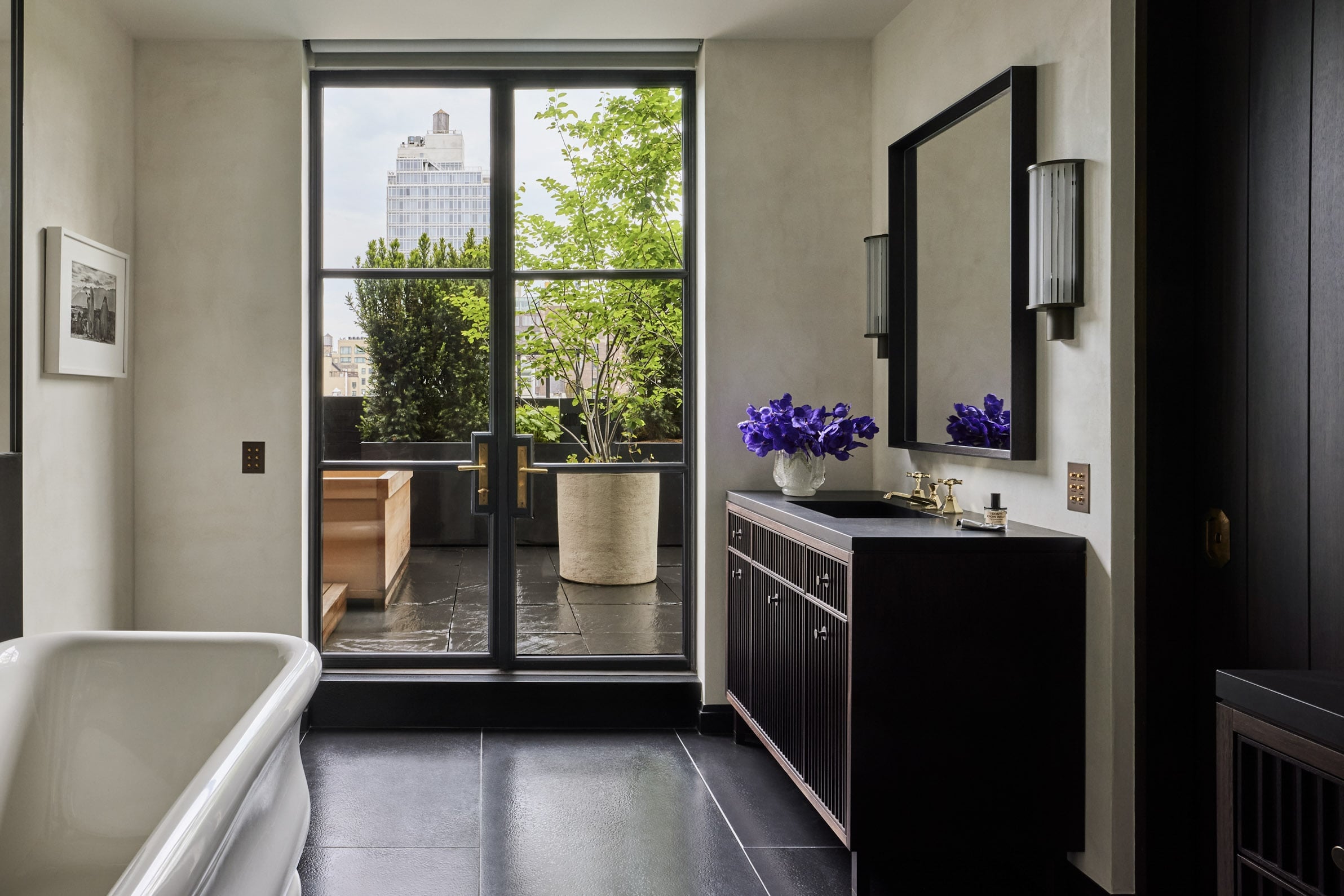A bathroom with a large tub and a view of the city.