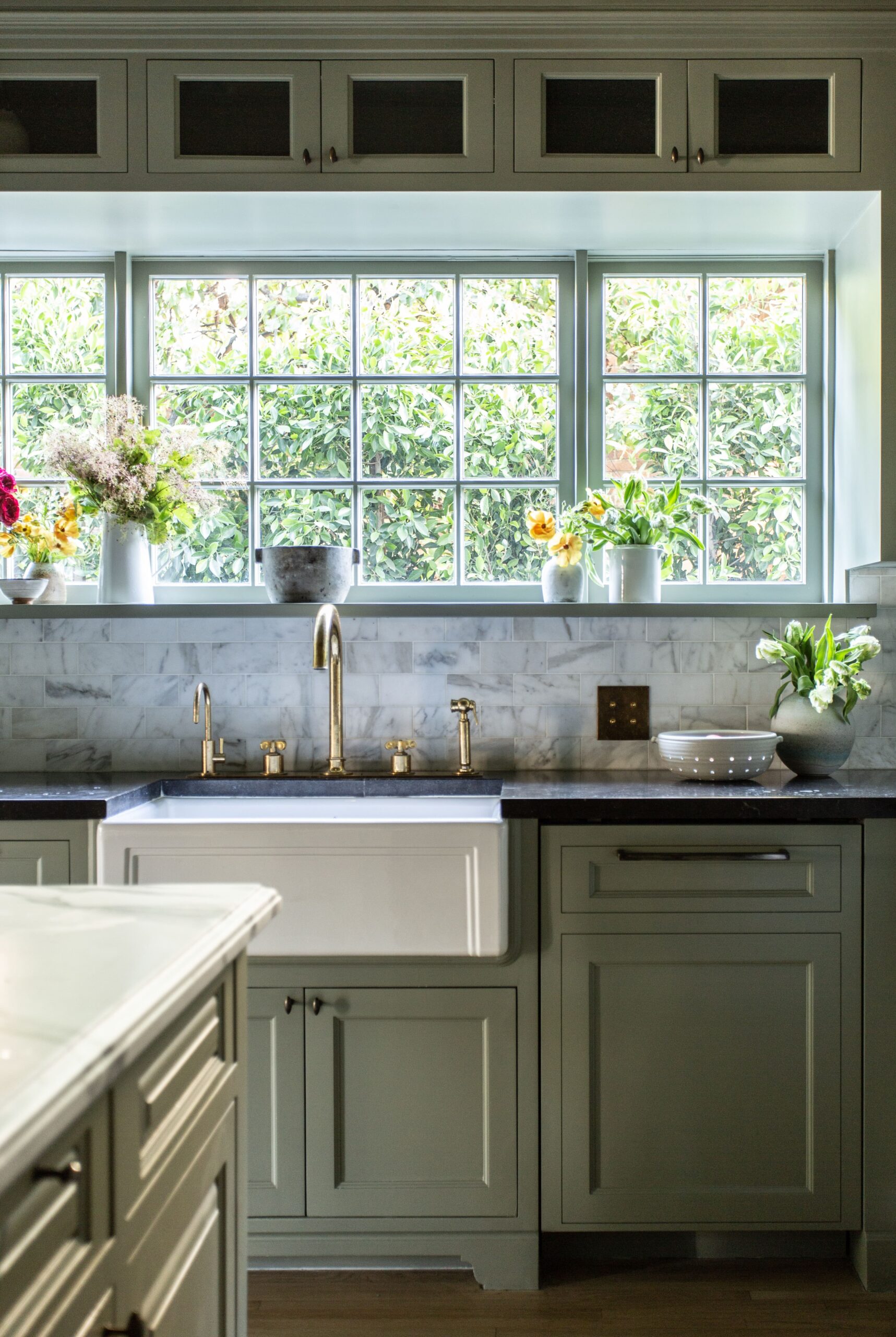 A kitchen with green cabinets and a window.