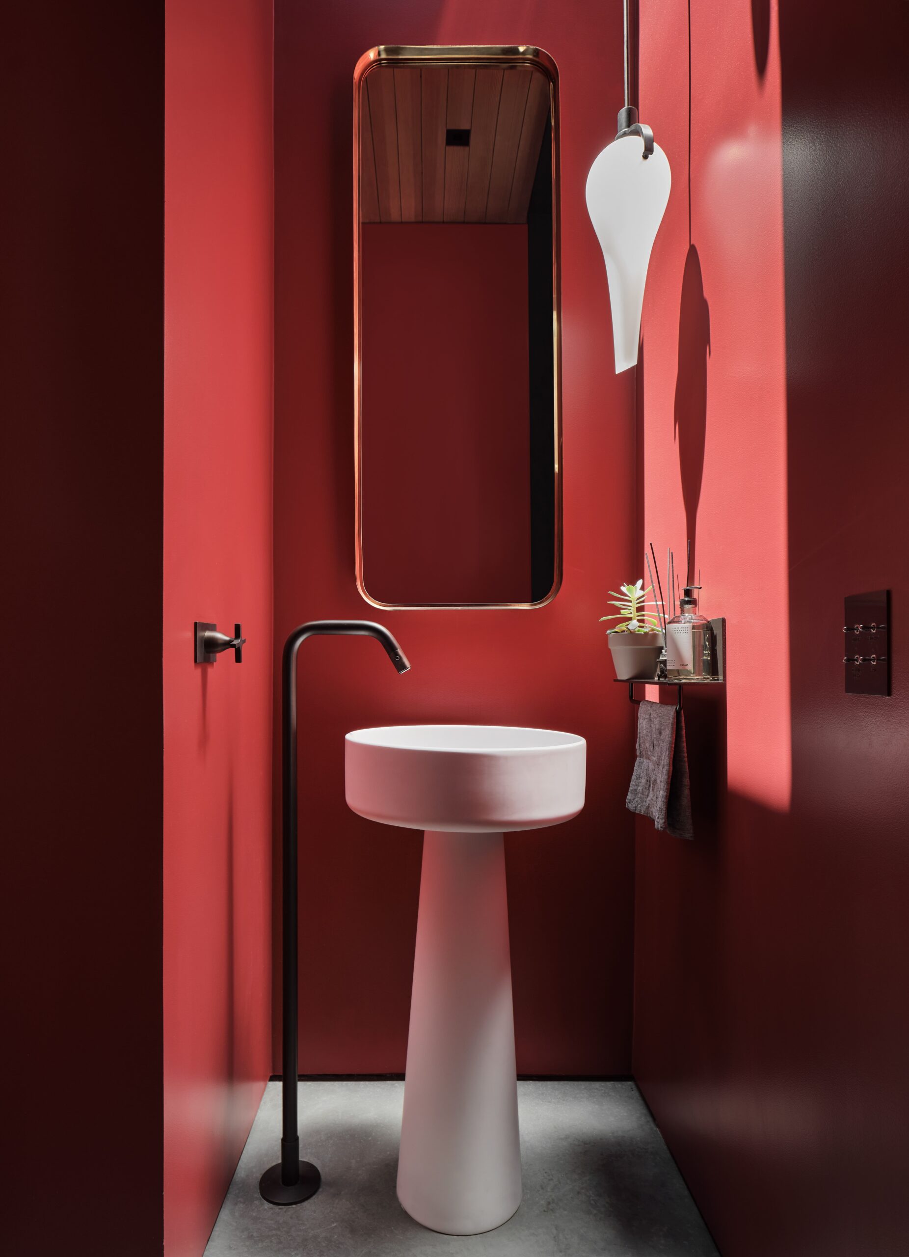 A bathroom with red walls and a sink.