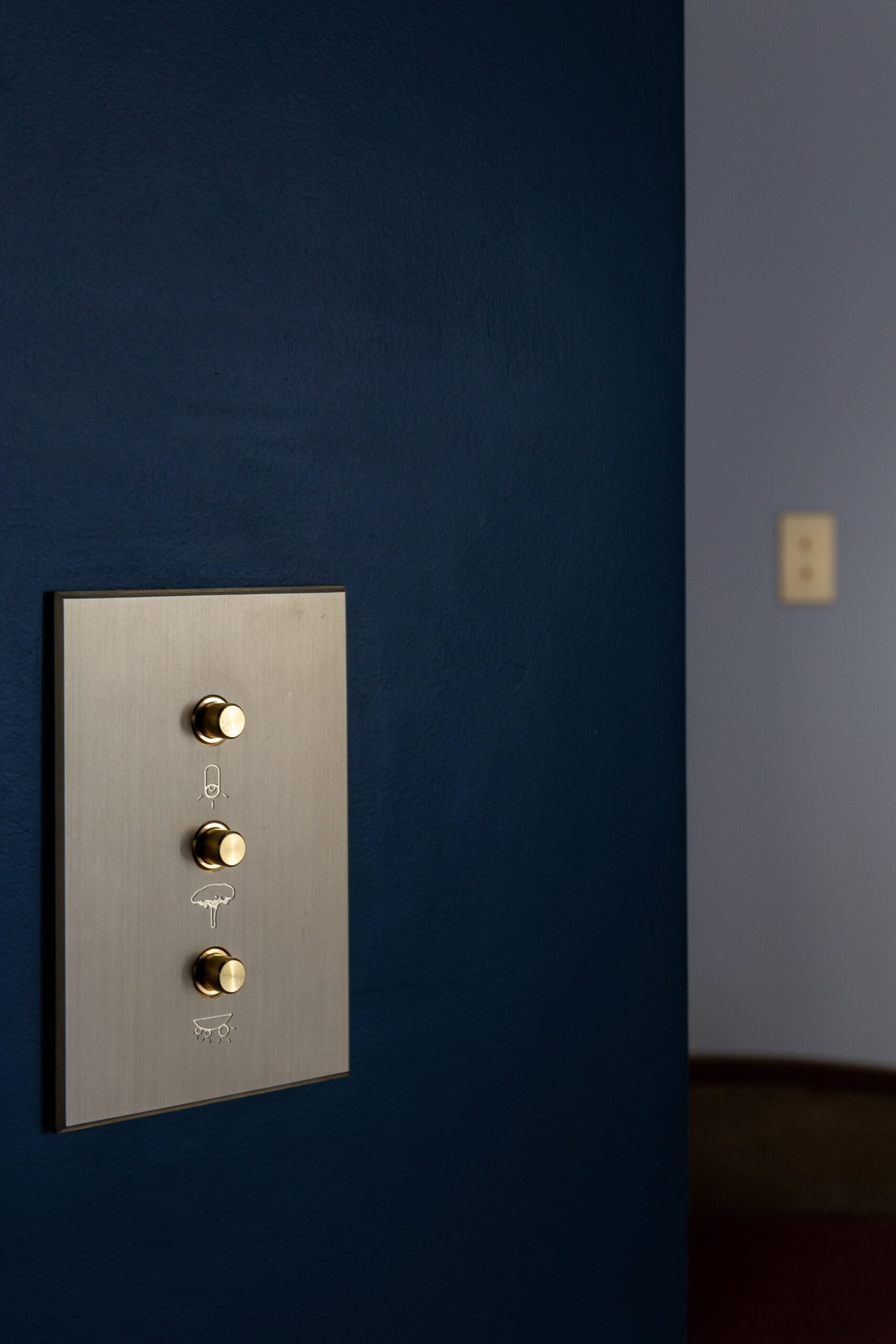 A light switch on a wall with a blue wall.