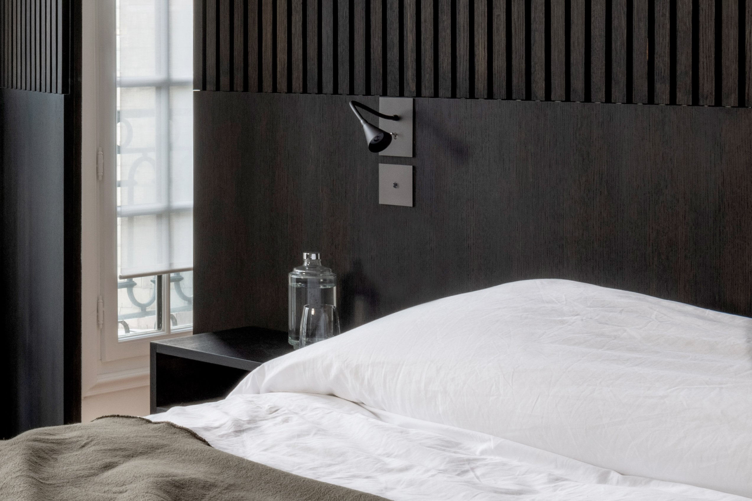 A bed in a room with a black headboard.