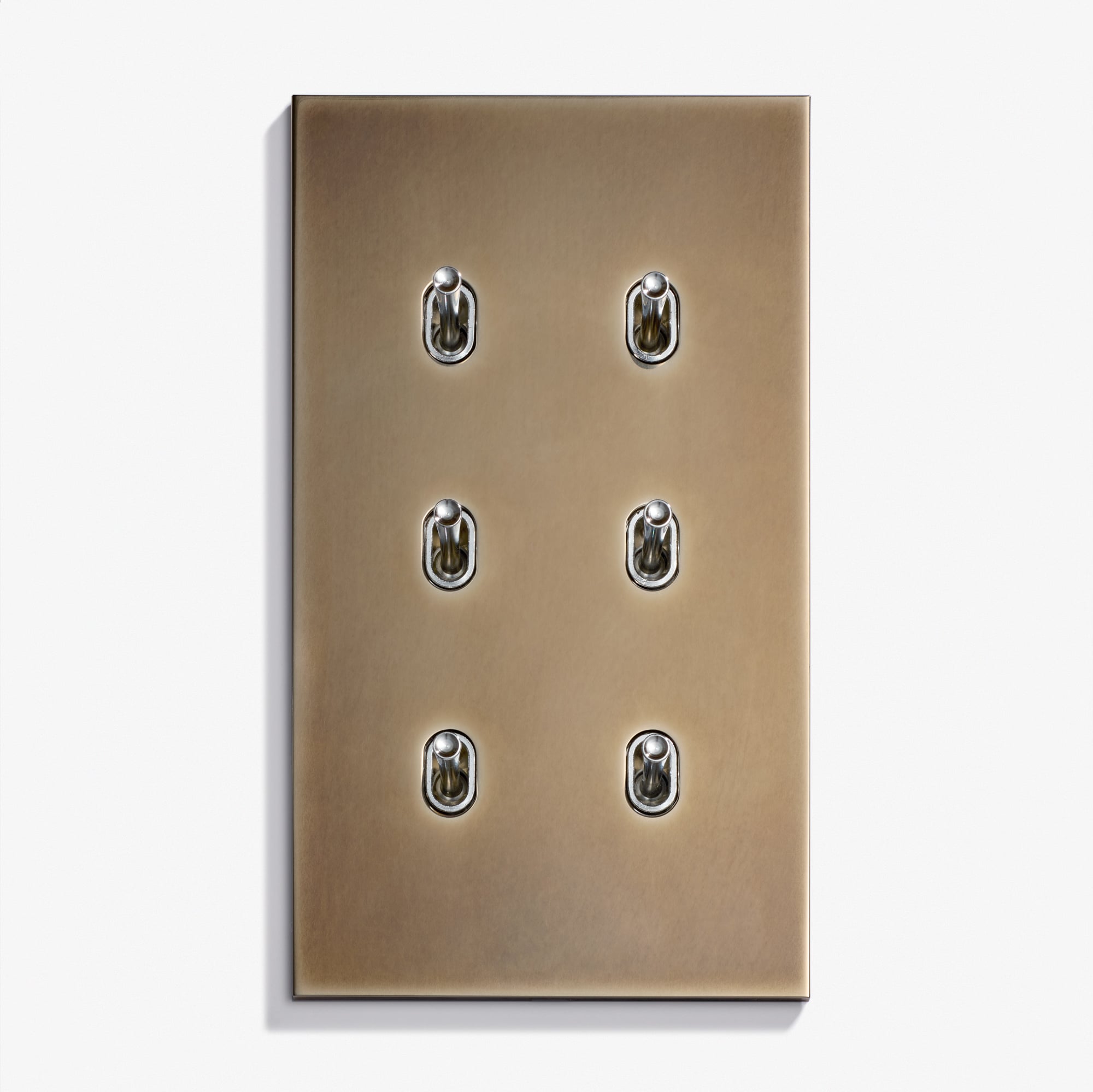 A brushed brass Ellipse Keypad 82 x 144 wall plate with six vintage-style toggle switches arranged in two columns and three rows, set against a plain white background.