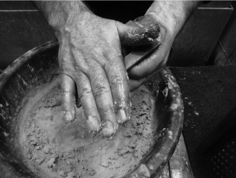 A black and white photo of a person's hands in a bowl.