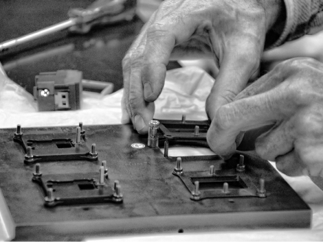 Close-up of hands fixing a computer component.