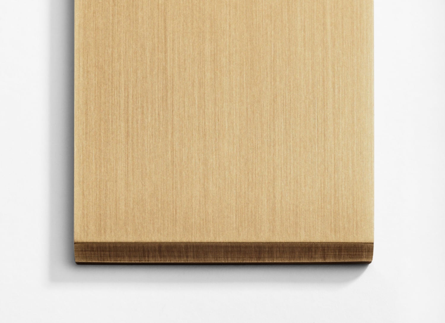 A wooden cutting board on a white surface.