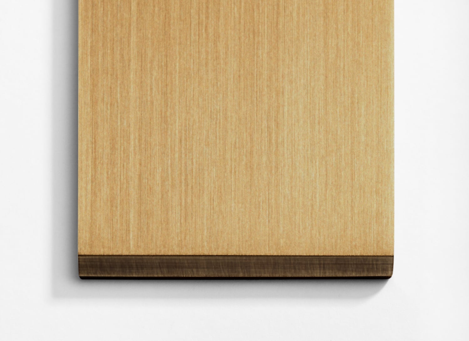 A wooden cutting board on a white surface.