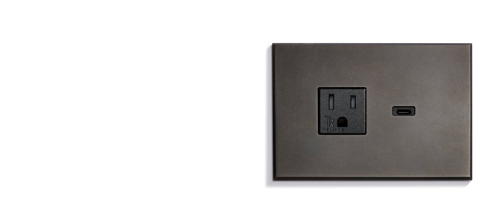 A dark-colored wall plate featuring one standard electrical outlet and one USB-C port, set against a plain white background.